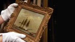 gloved hands holding a framed oil painting